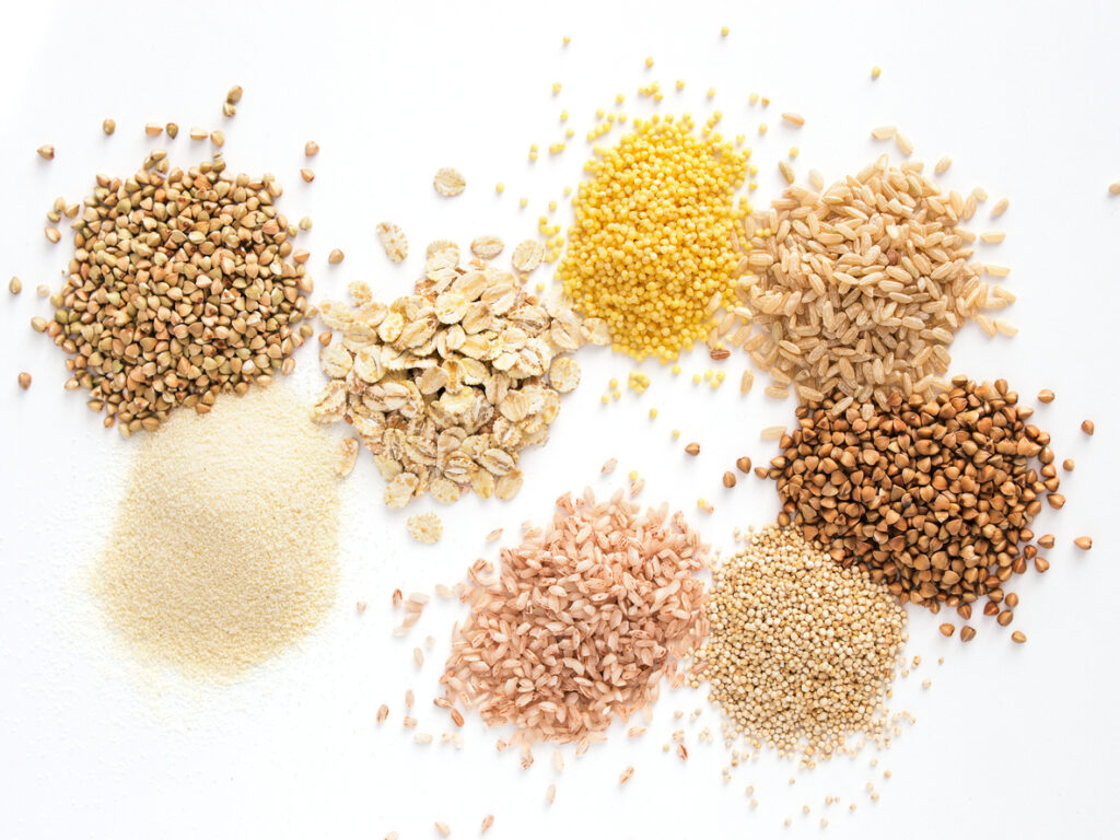 Set of heap various grains and cereals - raw green buckwheat, semolina, oat flakes, millet, brown rice, buckwheat or kasha,quinoa, and red rice.Isolated on white with clipping path.Top view.Copy space